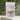Chamomile Tea in a soothing purple package with dried chamomile flowers gently scattered in the background.