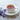 White cup of steaming tea with lavender flowers on a light surface